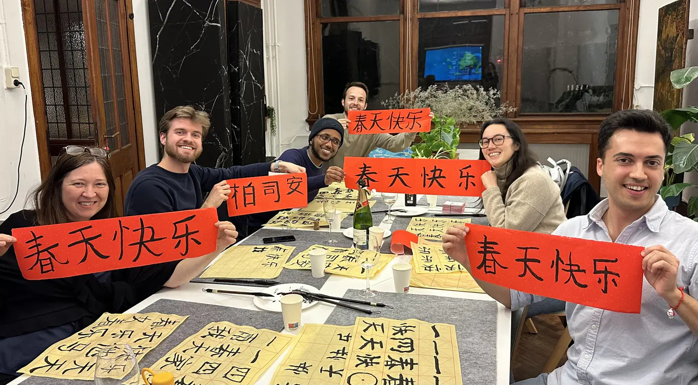 Workshop Chinees Nieuwjaar: deelnemers met rode lentespreuken die ze zelf in het Chinees schreven
