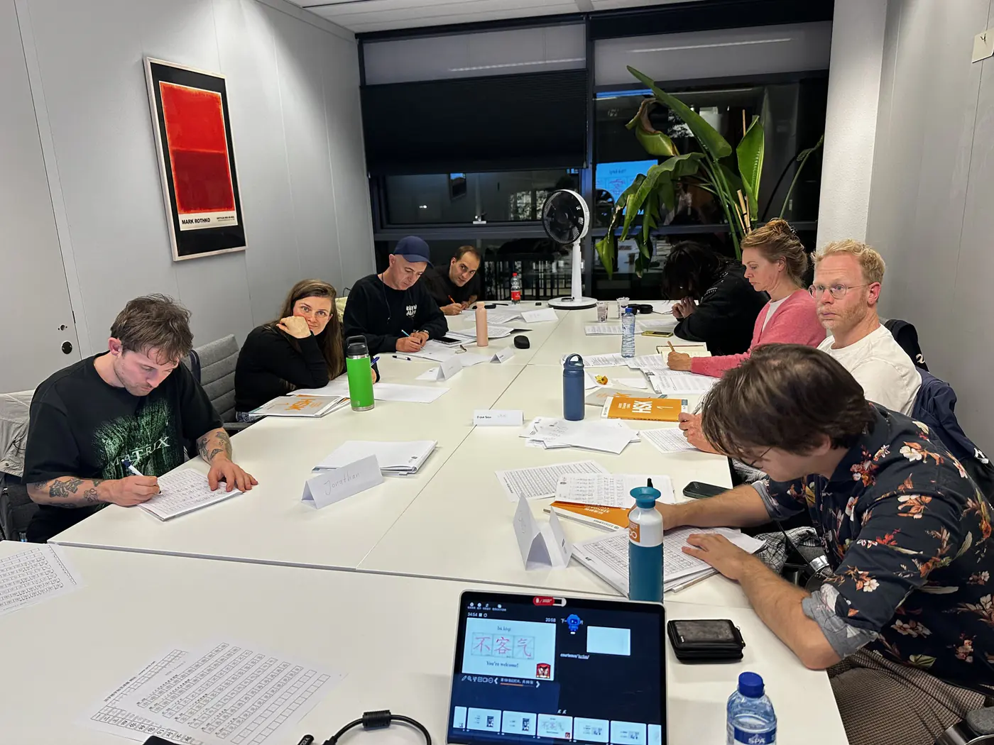 Chinese les in Amsterdam: een kleine groep volwassen cursisten schrijft Chinees aan tafel